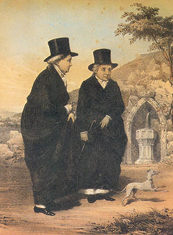 Two ladies wearing long black coats and black top hats